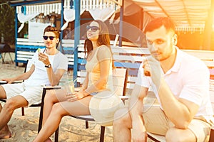 Young people enjoying summer vacation sunbathing drinking at beach bar