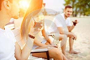 Young people enjoying summer vacation sunbathing drinking at beach bar