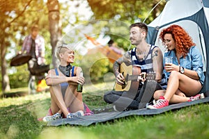 Young people enjoys on excursion with beer and guitar