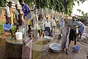 Young people fetch water at a water pump