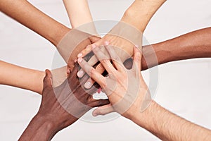 Young people fold their hands. Multinational friends with a stack of hands demonstrating unity and teamwork