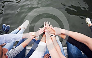 Young people friends sitting on the river bridge, lifestyle, feet over blue water