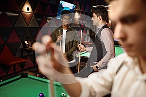 Young people friends or student playing billiards