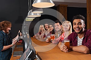 Young People Group In Bar, Barman Friends Sitting At Wooden Counter Pub, Drink Beer