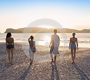 Young People Group On Beach At Sunset Summer Vacation, Friends Walking Seaside Back Rear View