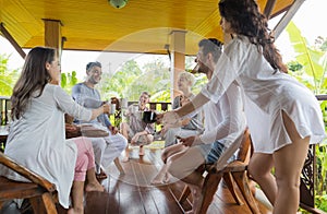 Young People Group Having Breakfast On Terrace Tropical Hotel, Friends Tropic Holiday Vacation