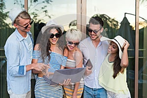 Young People Group On Terrace Tropical Hotel, Friends Using Cell Smart Phone Tropic Holiday Vacation