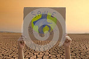 Young people hand with protest banner and dry land on background