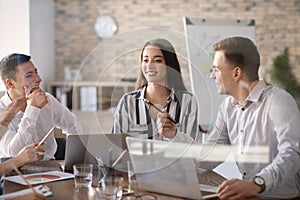 Young people having business meeting in office, view through glass