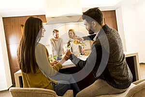 Young people having dinner and drinking wine in modern