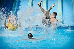 Young people having fun on water slides in aqua park photo