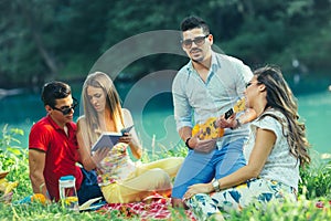 Young people having picnic near the river.