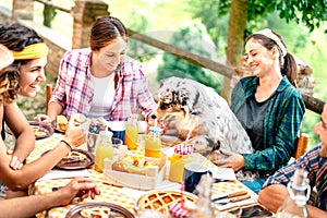 Young people on healthy pic nic breakfast with cute puppy at countryside farm house - Alternative lifestyle concept photo