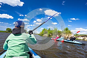 Young people are kayaking on a river in beautiful nature. Summer sunny day