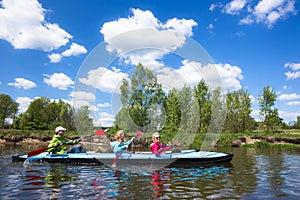 Young people are kayaking on a river in beautiful nature. Summer sunny day