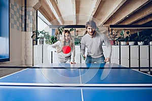 Young people, man and woman playing table tennis