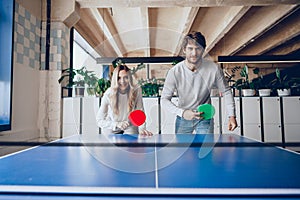 Young people, man and woman playing table tennis