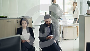 Young people man and woman are waiting for job interview in office while manager is interviewing another candidate. Girl