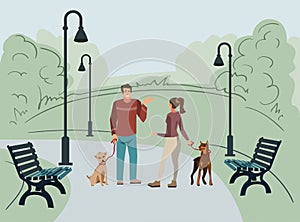 Young people, man and woman, walk in the park with their dogs in the morning
