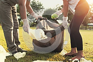 young people picking up garbage plastic for cleaning at park