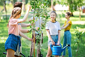 young people planting new trees and volunteering in park