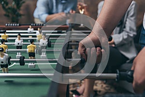 Young people playing foosball indoors