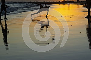 Young people playing sand football at sunset on Ondina beach