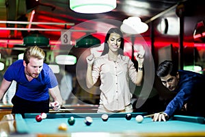 Young people playing snooker in a club pub bar