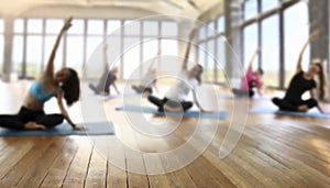 Young people practicing yoga in gym, focus on foreground