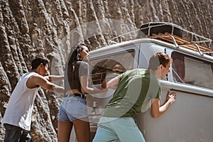 Young people push broke down retro van