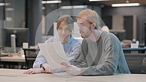 Young People Reading Documents in Office