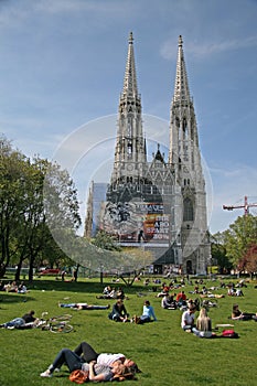 Young people relaxing on the grass of Sigmund Freud Park near The Votive Church (Votivkirche). VIENNA, AUSTRIA