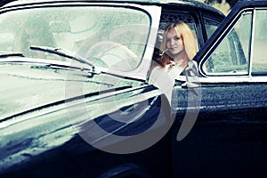 Young people in retro car in the rain