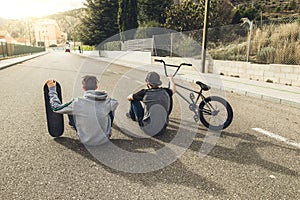 Young people riding bikes and skateboards in the city. Modern people with a skate and a bmx down the street