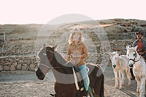 Young people riding bitless horses inside corral - Wild couple having fun in equestrian ranch  - Training, culture, passion,