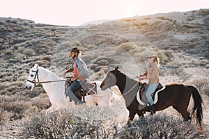 Young people riding horses doing excursion at sunset - Wild couple having fun in equestrian tour  - Training, culture, passion,