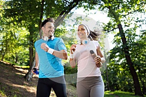 Young people running outdoors. Couple or friends of runners exercising in park photo