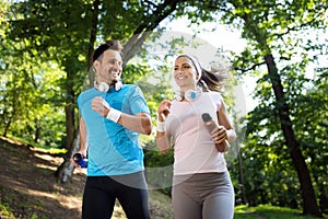 Young people running outdoors. Couple or friends of runners exercising in park