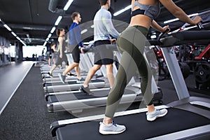 Young people running on treadmill in gym