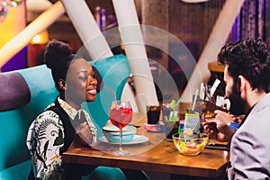 Young people sitting in a cafe and talking. Young man and woman meeting at cafe table.