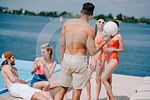 young people spending time together at poolside