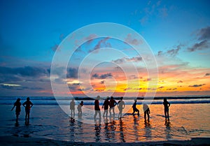 Young people at sunset beach in Kuta, Bali