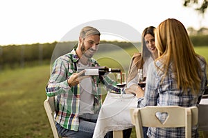 Young people by the table in the vineyard