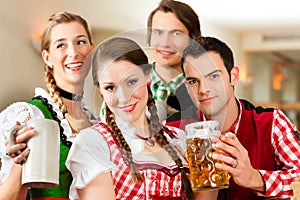 Young people in traditional Bavarian Tracht in restaurant or pub