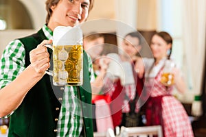 Young people in traditional Bavarian Tracht in restaurant or pub