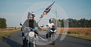 Young people travel on motorcycles with the U.S. flag
