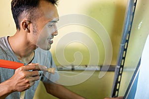 Young people use a sprayer to peel off the rubber on the silkscreen