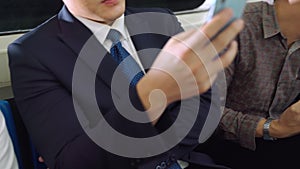 Young people using mobile phone in public underground train