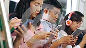 Young people using mobile phone in public underground train