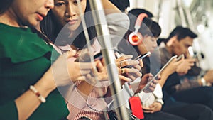 Young people using mobile phone in public underground train